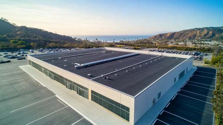 A commercial roof on a manufacturing plant in a location similar to Malibu with an architectural photography aesthetic (AI image)