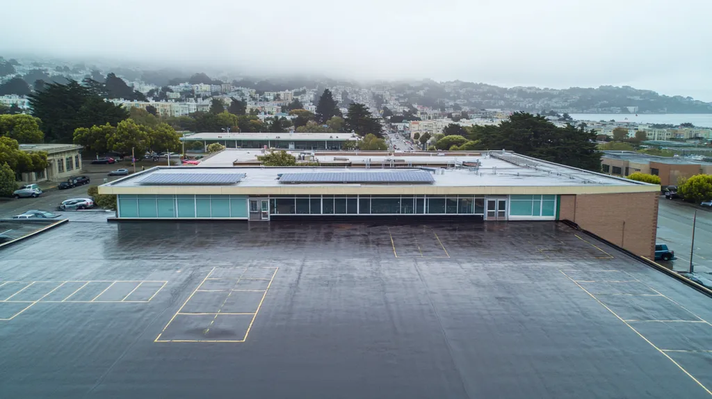 A commercial roof on a school in a location similar to San Francisco with a rainy day aesthetic (AI image)
