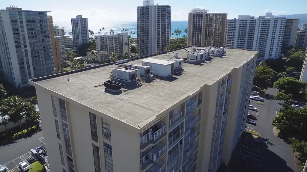 A commercial roof on high-rise apartments in a location similar to Honolulu with an urban context aesthetic (AI image)