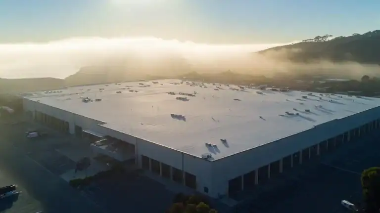 A commercial roof on a warehouse in a location similar to Big Sur with a light beams aesthetic (AI image)