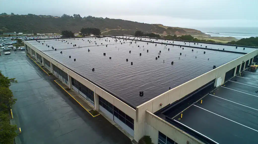 A commercial roof on a warehouse in a location similar to Big Sur with a rainy day aesthetic (AI image)