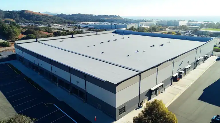 A commercial roof on a warehouse in a location similar to Big Sur with an urban context aesthetic (AI image)