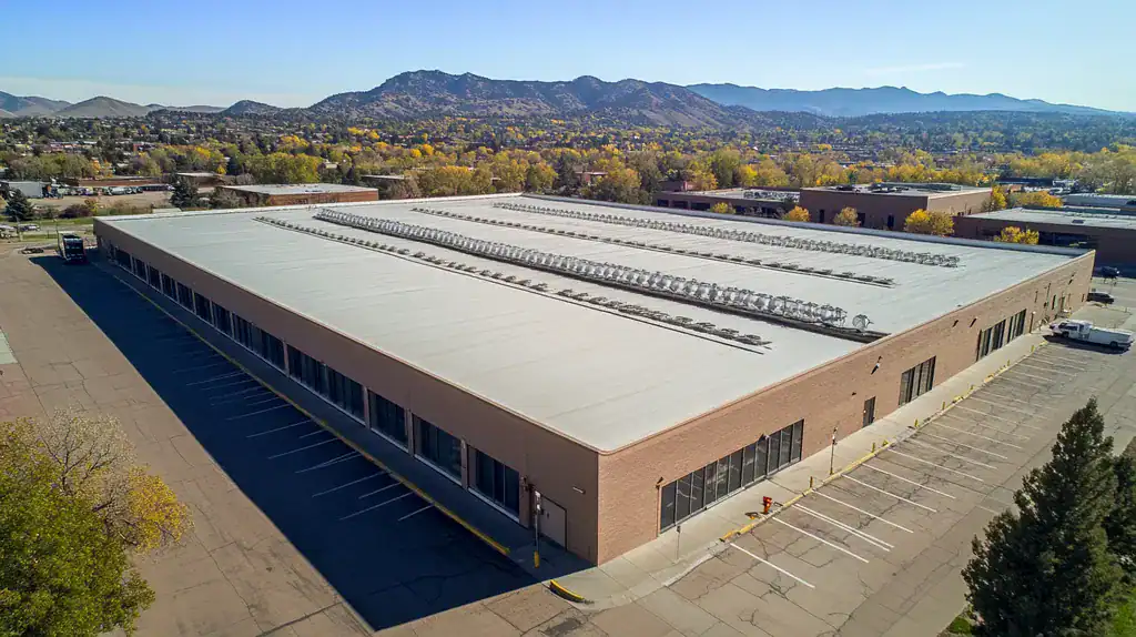 A commercial roof on a warehouse in a location similar to Boulder with an architectural photography aesthetic (AI image)